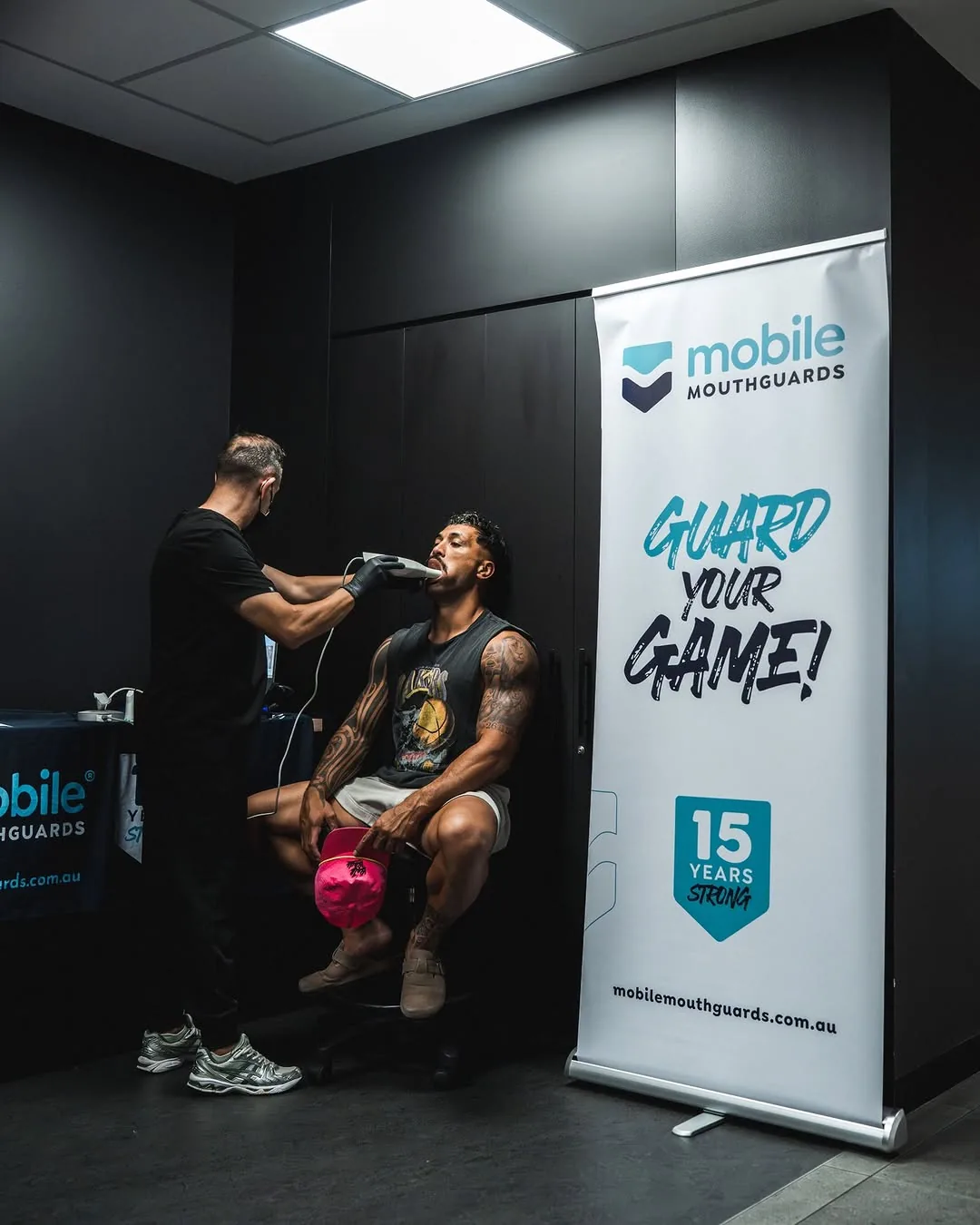 An adult player has his teeth scanned beside the Mobile Mouthguards banner.