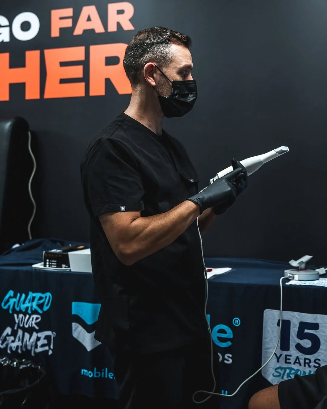 The technician prepares the handheld scanner at a mobile fitting event.