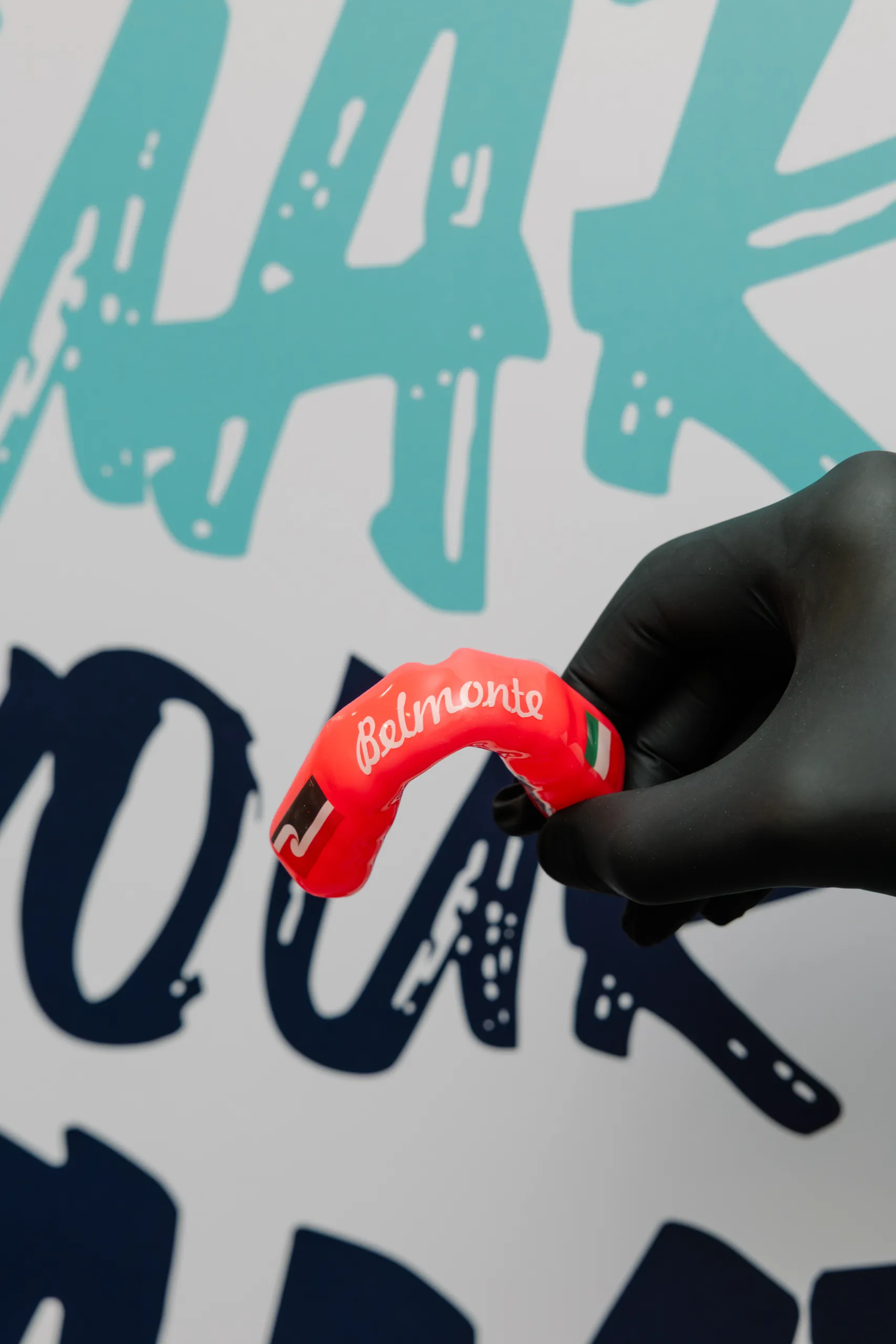 Red custom mouthguard with white Belmonte lettering and Italian flag artwork.