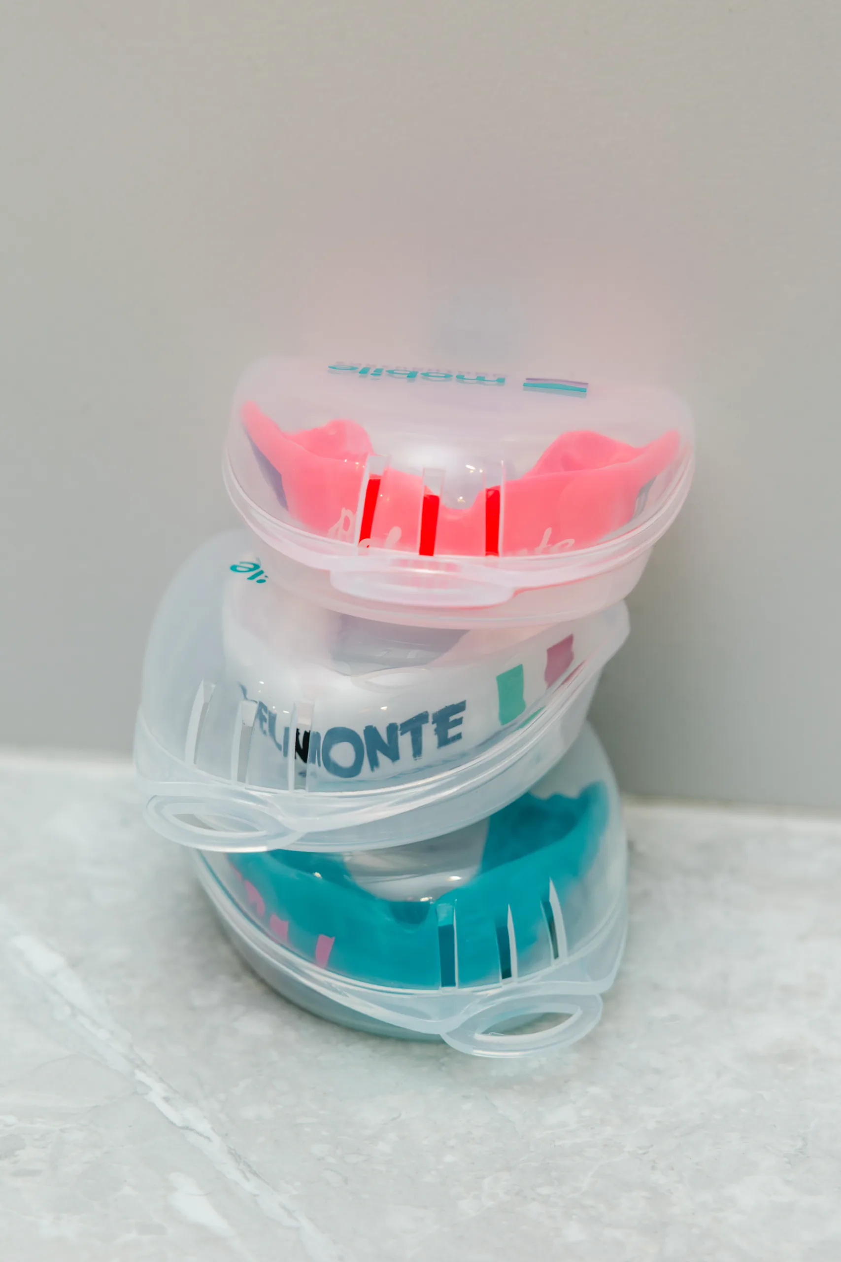 Finished custom mouthguards stacked in their clear cases.